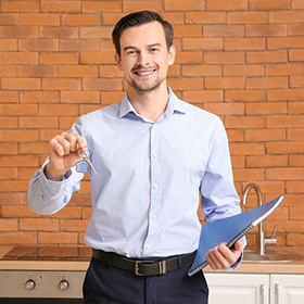 Man Holding Keys and a Notebook