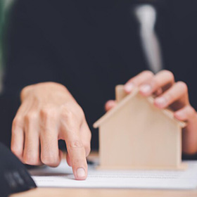 A Person Holding a Carton House